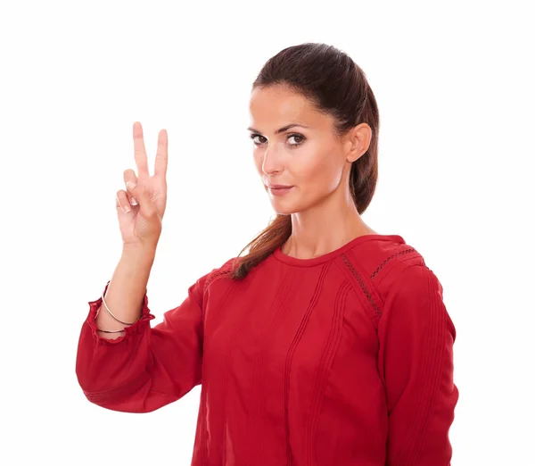 Привлекательная женщина на красной рубашке с знаком победы — стоковое фото