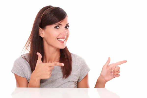 Hispanic woman pointing to her left — Stock Photo, Image