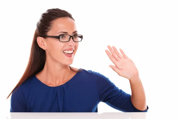 Friendly girl with glasses gesturing a greeting — Stock Photo, Image