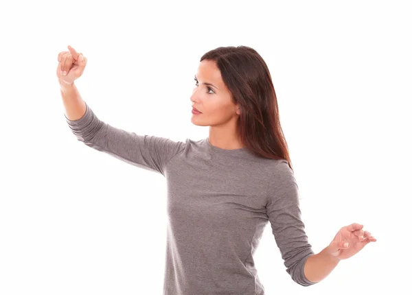 Woman in grey blouse pointing to her right — Stock Photo, Image