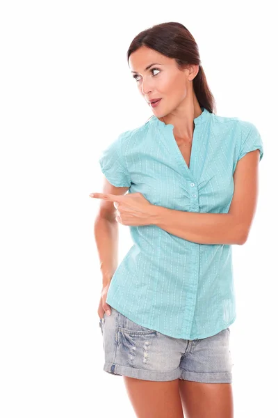 Chica en jeans cortos mirando a su derecha señalando —  Fotos de Stock