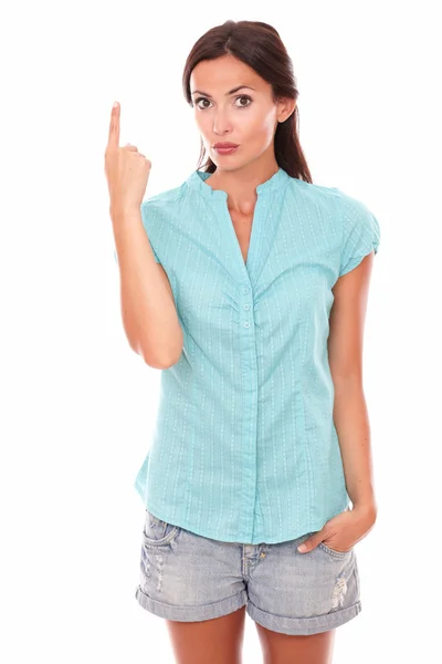 Kvinna i kort jeans pekar uppåt — Stockfoto