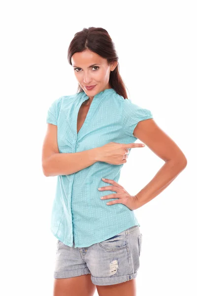 Hispanic in short jeans pointing to her left — Stock Photo, Image