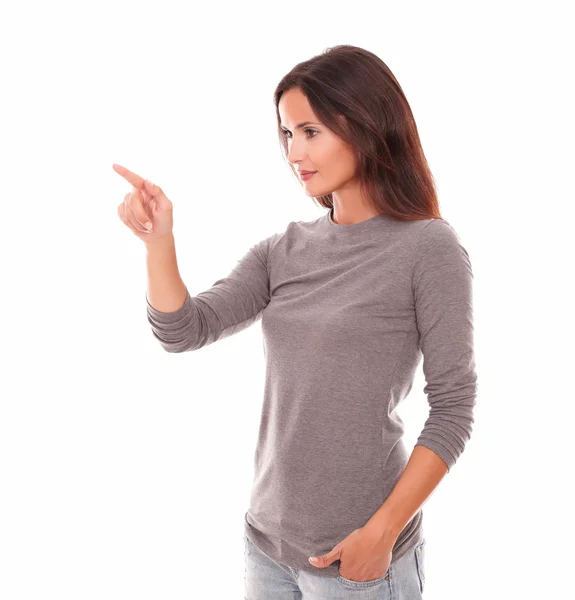 Girl in grey blouse pointing to her right — Stock Photo, Image