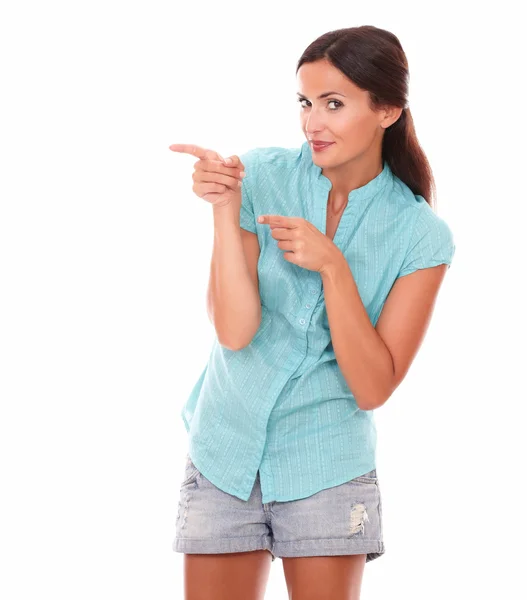 Pretty hispanic woman in short jeans pointing — Stock Photo, Image