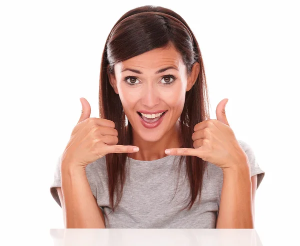 Charming lady with phone gesture looking at camera — Stock Photo, Image