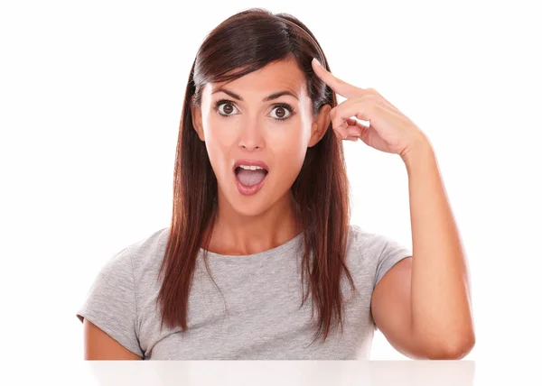 Surprised young woman pointing to her head — Stock Photo, Image