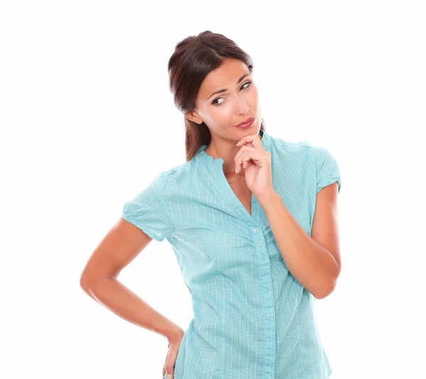 Girl in blue shirt holding chin and wondering — Stock Photo, Image