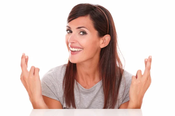 Senhora atraente cruzando os dedos enquanto sorri — Fotografia de Stock