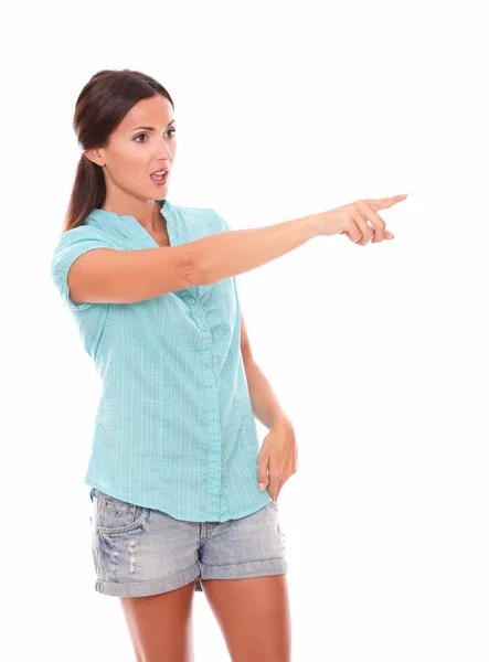 Mujer soltera en jeans cortos apuntando a su izquierda —  Fotos de Stock