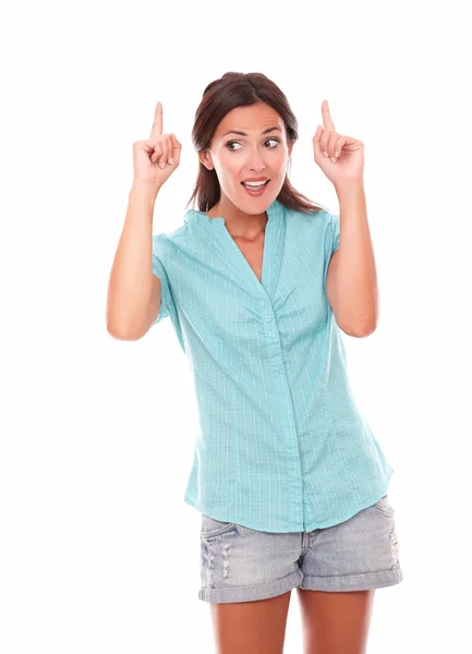 Young brunette woman in blue blouse pointing up — Stock Photo, Image