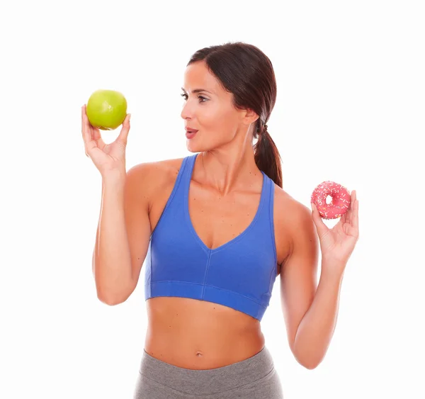 Sporty adult woman smiling at fruit — Stock Photo, Image