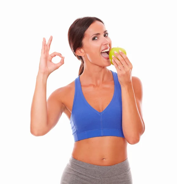 Hispanic adult woman in sportswear biting apple — Stock Photo, Image