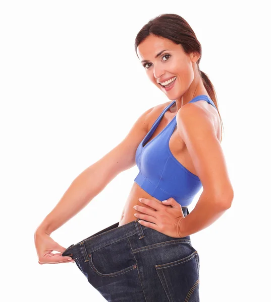 Fit latin woman pulling jeans on waist — Stock Photo, Image