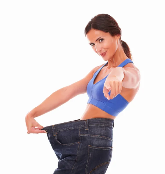 Fit lady happily pulling jeans on waist — Stock Photo, Image