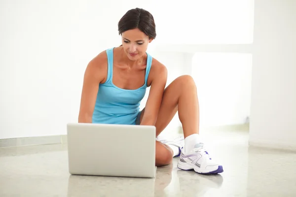 Vriendelijke brunette werken op haar laptop — Stockfoto