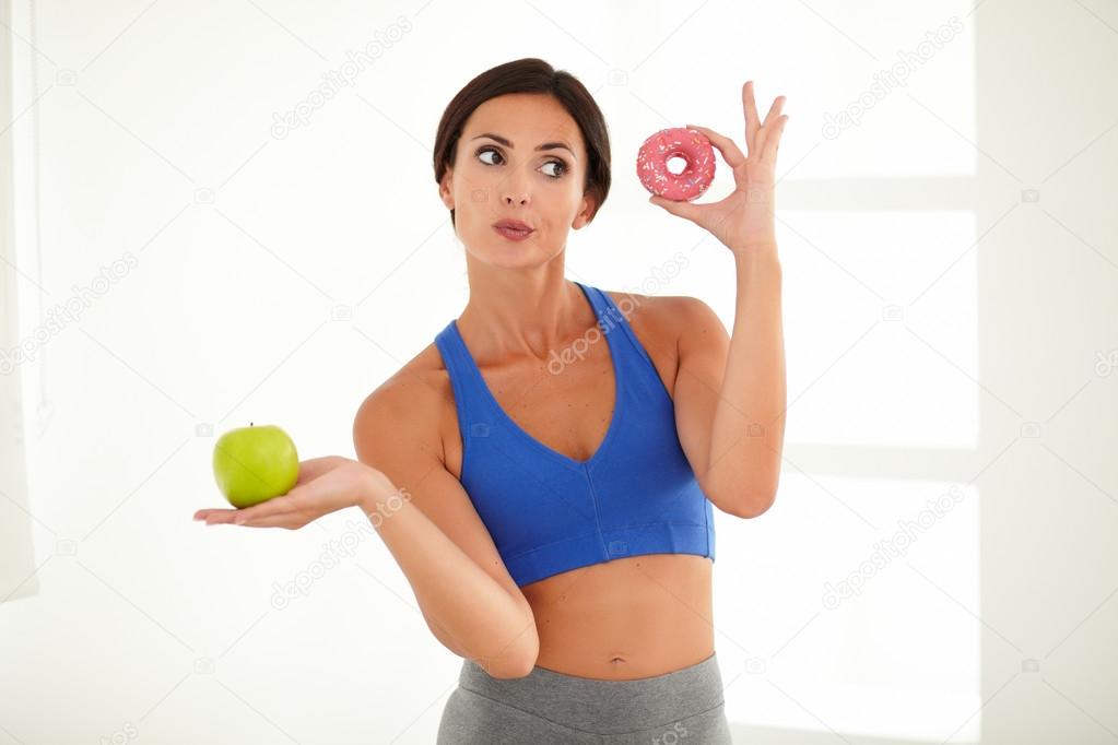Dieting young lady choosing food for fitness