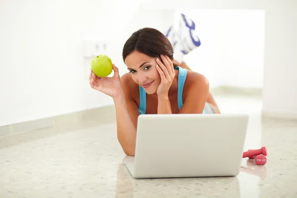 Young woman in sportswear working on computer — Stock Photo, Image