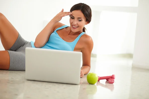 Sportieve vrouw werken op haar laptop — Stockfoto