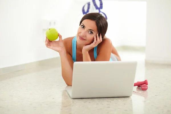 Pretty female laying and browsing on her laptop — Stock Photo, Image