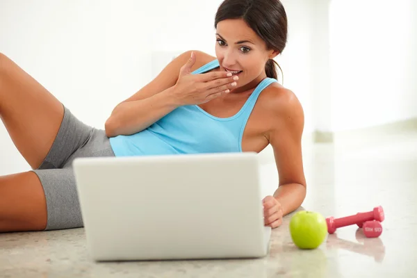 Friendly female looking surprised and using laptop — Stock Photo, Image