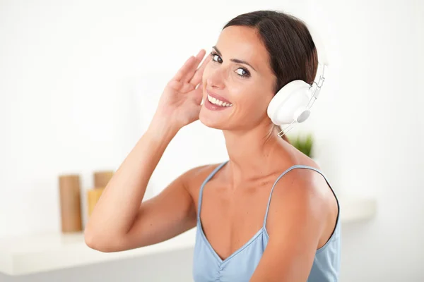 Femme sophistiquée avec écouteurs regardant heureux — Photo