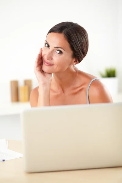 Raffinierte Frau arbeitet an ihrem Laptop — Stockfoto