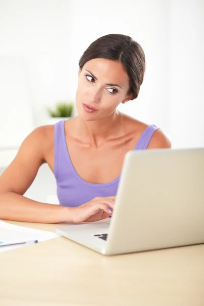 Hübsche brünette Frau sitzt und arbeitet — Stockfoto