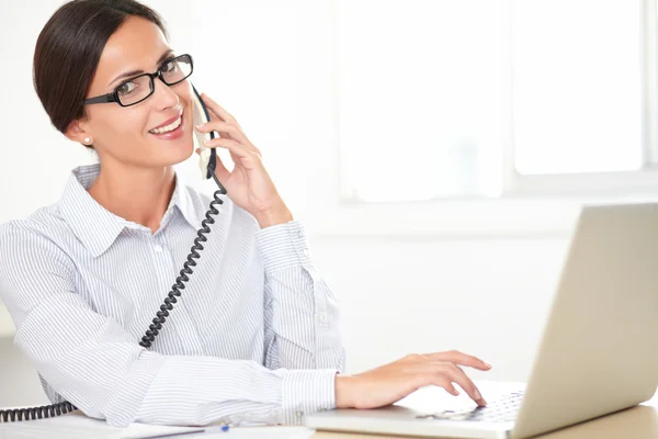 Hispanic female employee conversing on the phone — Stock Photo, Image