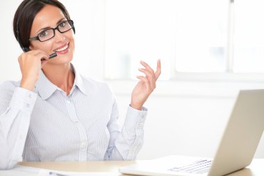 Latin kız resepsiyonist onu kulaklık üzerinde söyleşmek