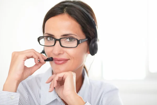 Junge charmante Sekretärin spricht über Kopfhörer — Stockfoto