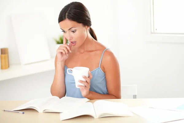 Mooie vrouw op zoek verrast tijdens het lezen — Stockfoto