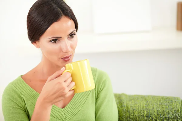 Genç kadın bir fincan sıcak kahve üfleme — Stok fotoğraf