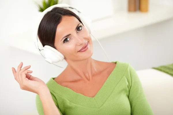 Sorridente giovane donna che ascolta musica — Foto Stock