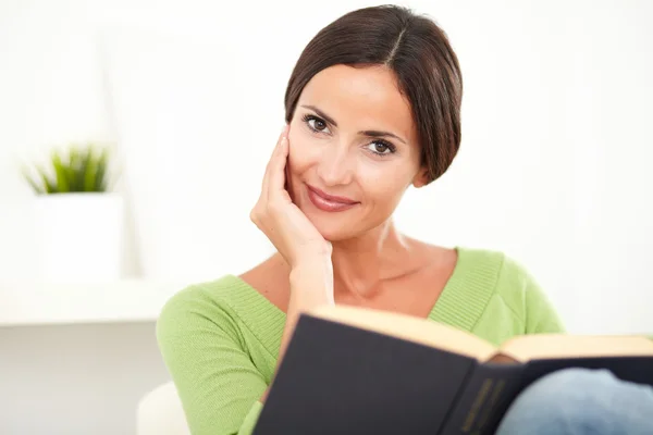 Smiling young woman holding a book — Stock Photo, Image