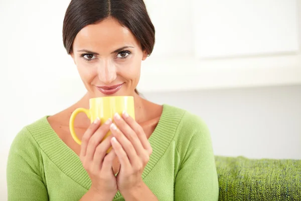 Sorrindo senhora segurando uma caneca amarela — Fotografia de Stock