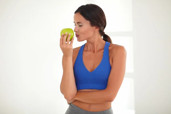 Woman standing and kissing fruit — Stock Photo, Image