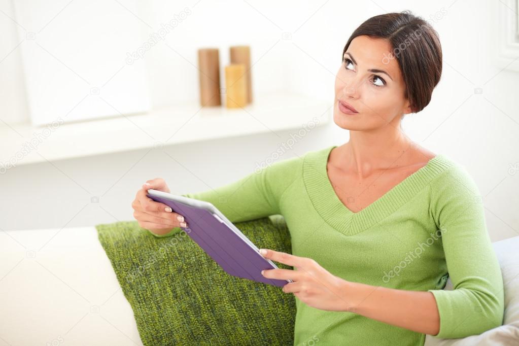 Thoughtful woman with tablet