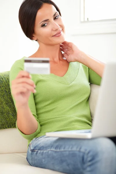 Ontspannen vrouw kijken naar de credit card — Stockfoto