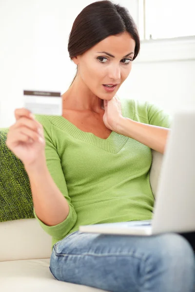 Woman looking surprised at the credit card — Stock Photo, Image