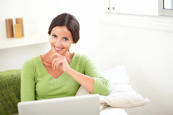Jovem mulher sorrindo e usando um laptop — Fotografia de Stock
