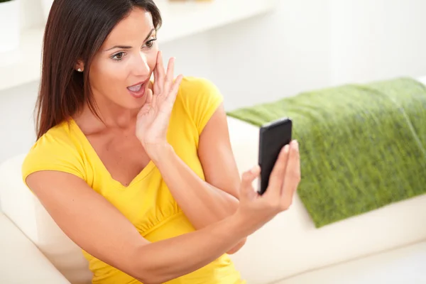 Verrast vrouw met behulp van een mobiele telefoon — Stockfoto