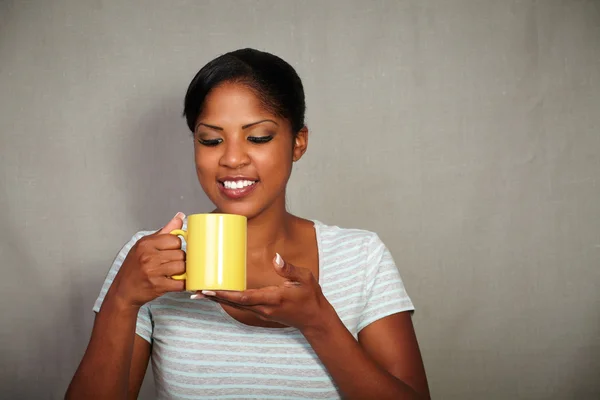 Glückliches Mädchen, das eine Kaffeetasse hält und lächelt — Stockfoto