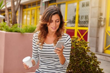 Neşeli kadın akıllı telefon oturma sırasında kullanarak
