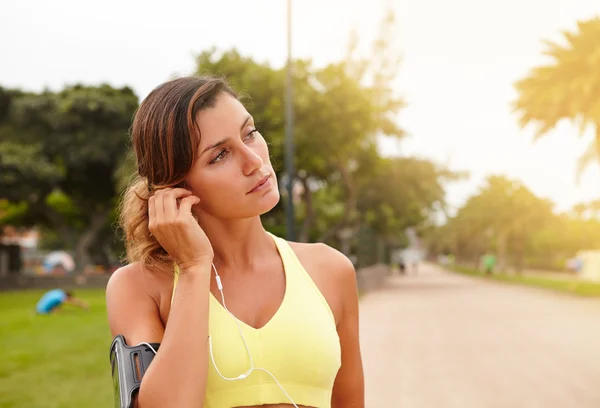 Sportovní žena s sluchátka venku — Stock fotografie