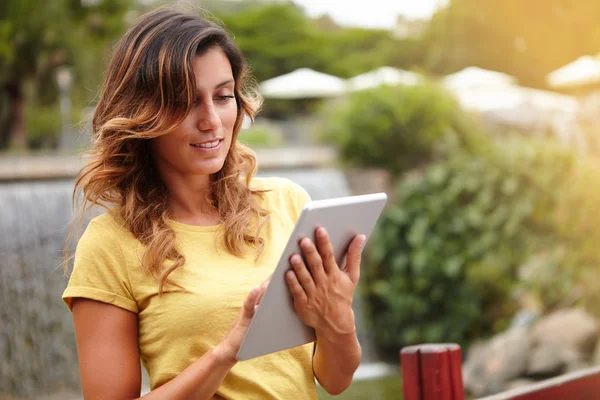 Mujer que usa la tableta de PC en el parque — Foto de Stock