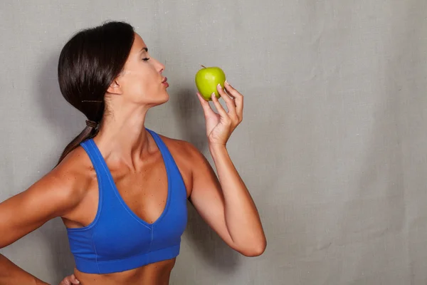 Sport female holding and kissing apple — Stock Photo, Image