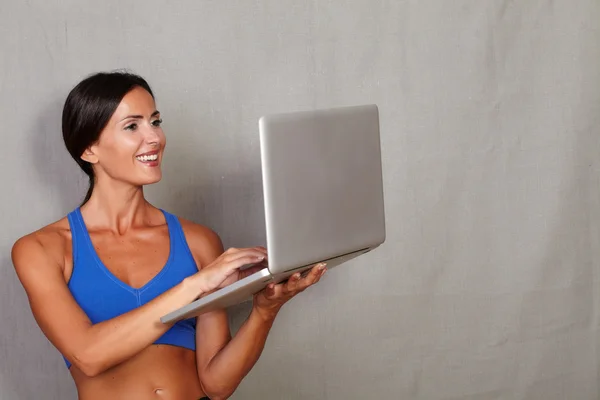 Sporty woman using laptop — Stock Photo, Image