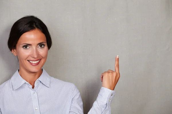 Young businesswoman smiling and pointing up — Stock Photo, Image