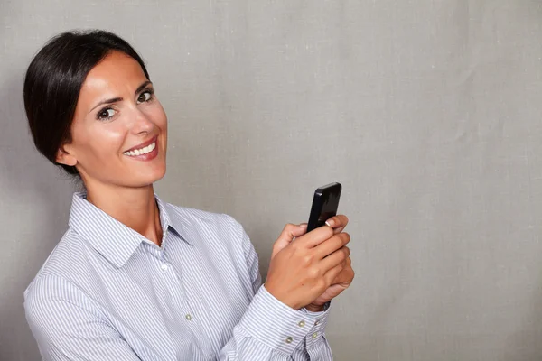 Jovem empresária segurando telefone celular — Fotografia de Stock